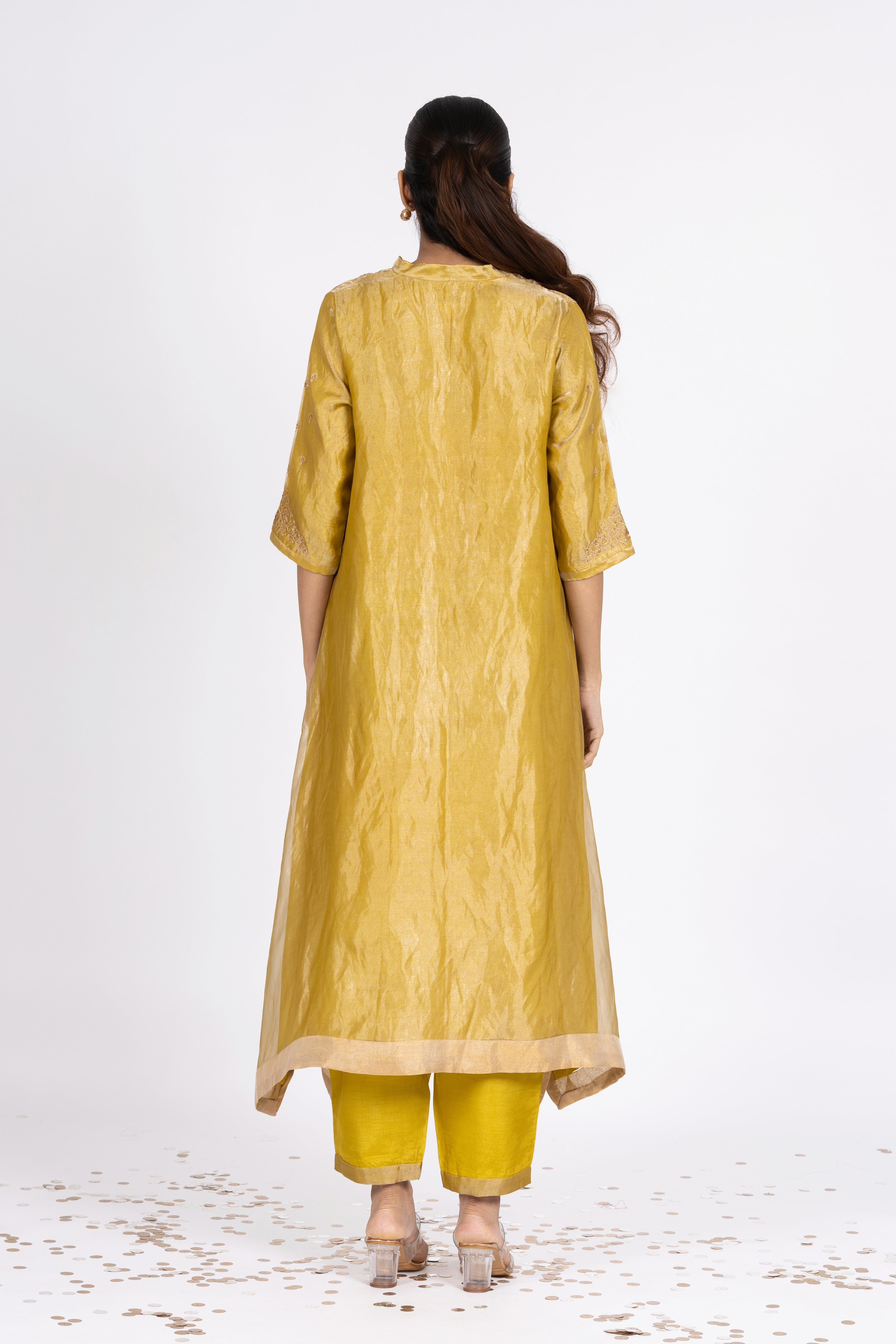 Woman wearing a Green Tissue kurta with gold embroidery on a white background