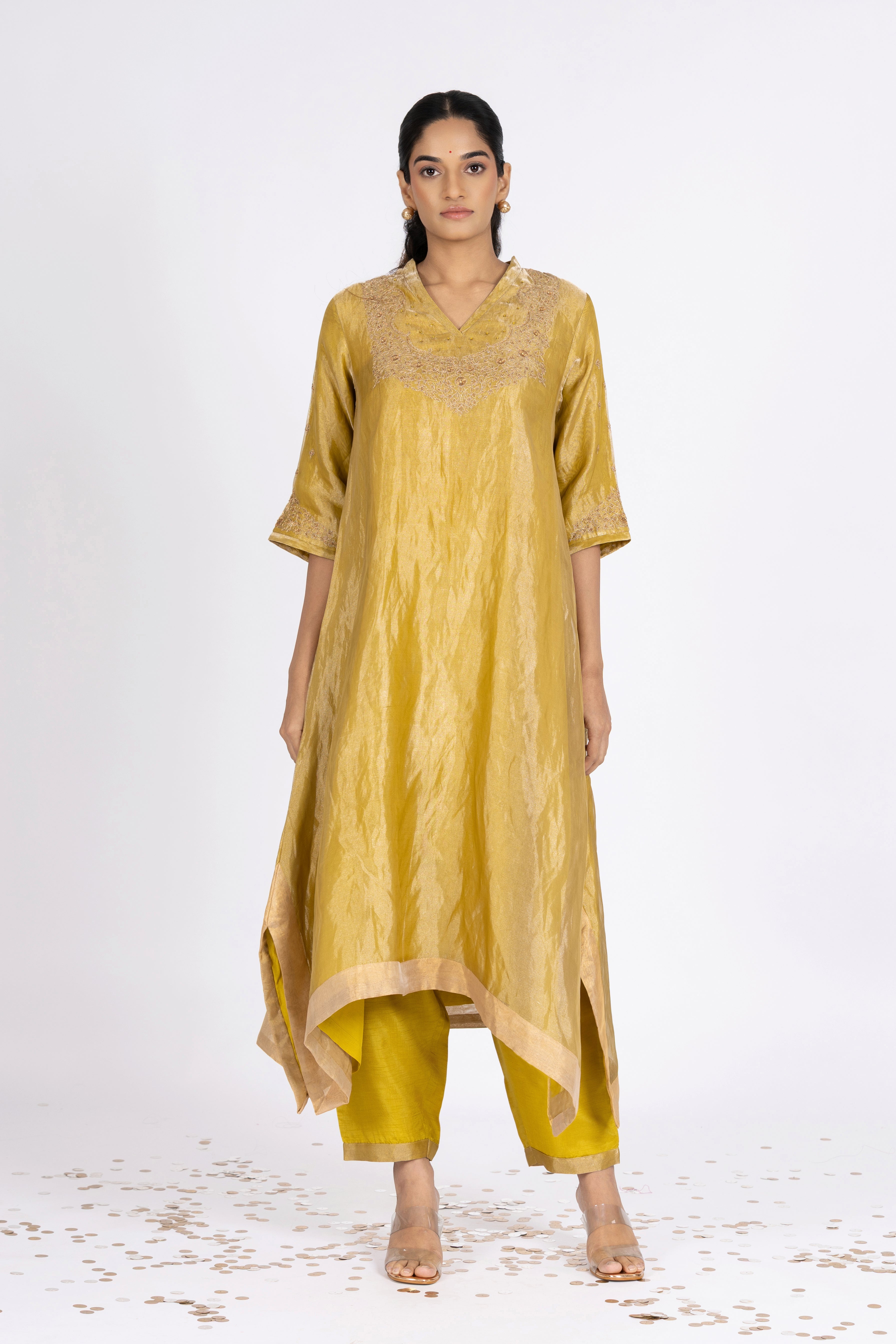 Woman wearing a Green Tissue kurta with gold embroidery on a white background