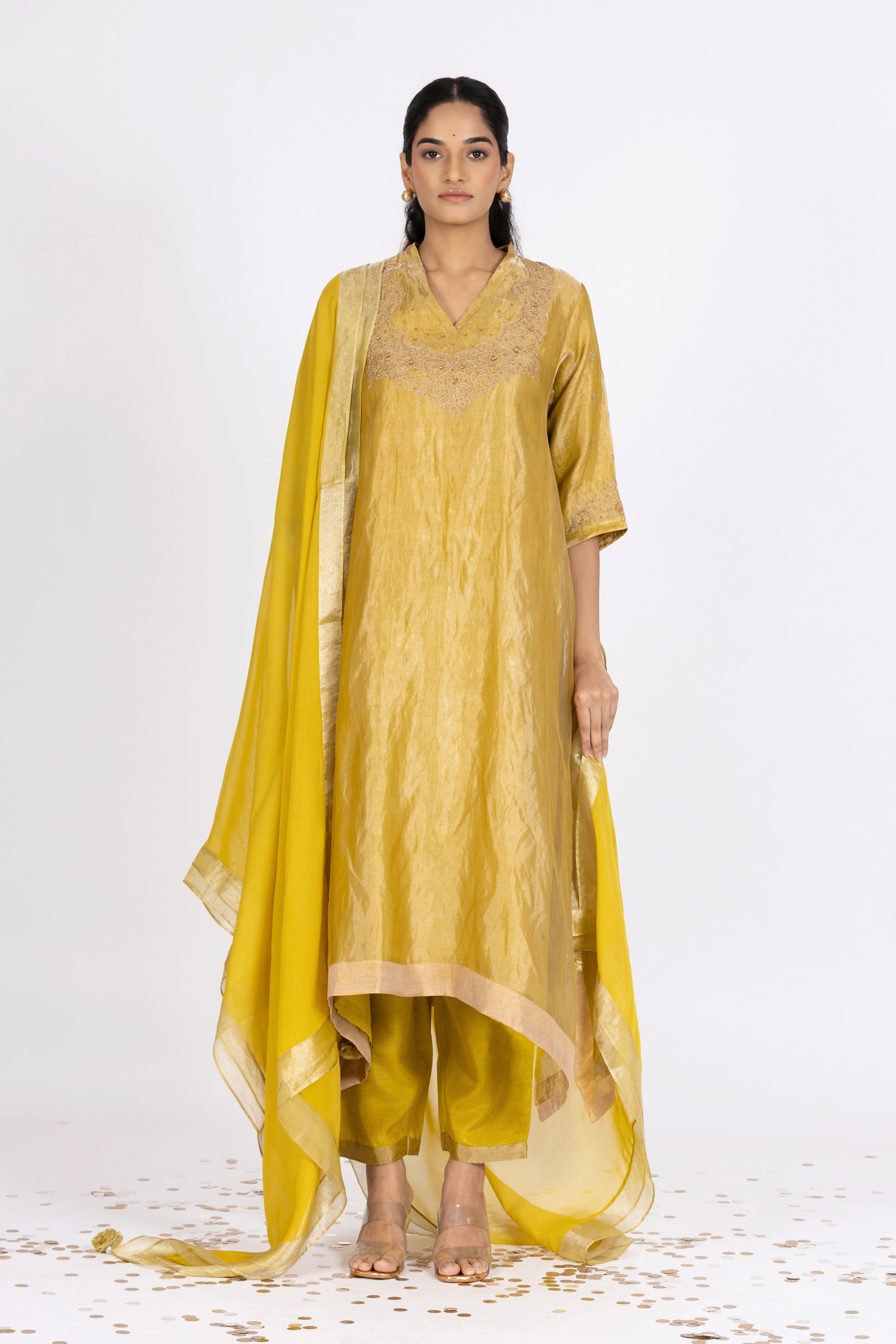 Woman wearing a Green Tissue kurta with gold embroidery on a white background