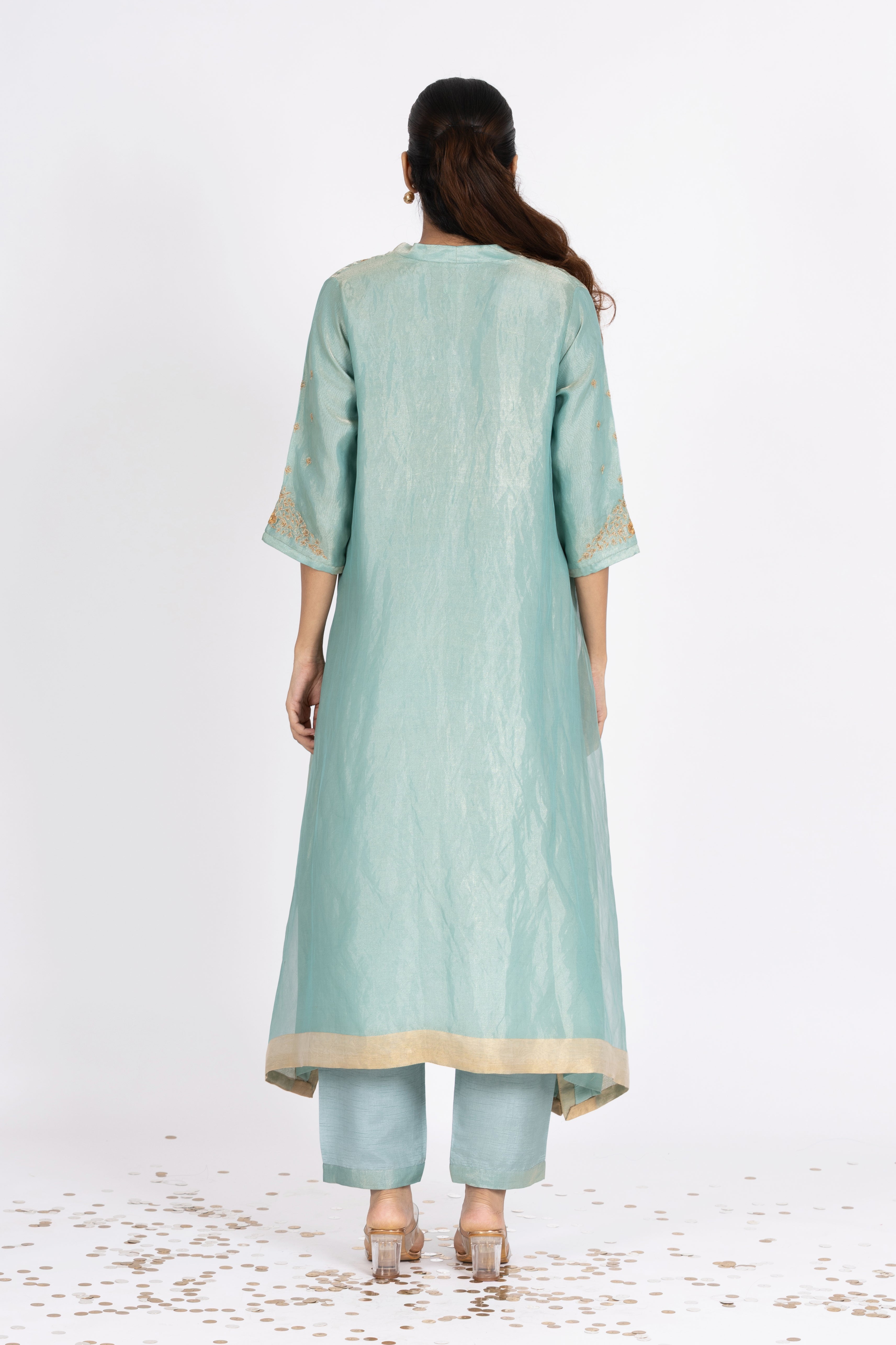 Woman wearing a blue Tissue kurta with gold embroidery on a white background