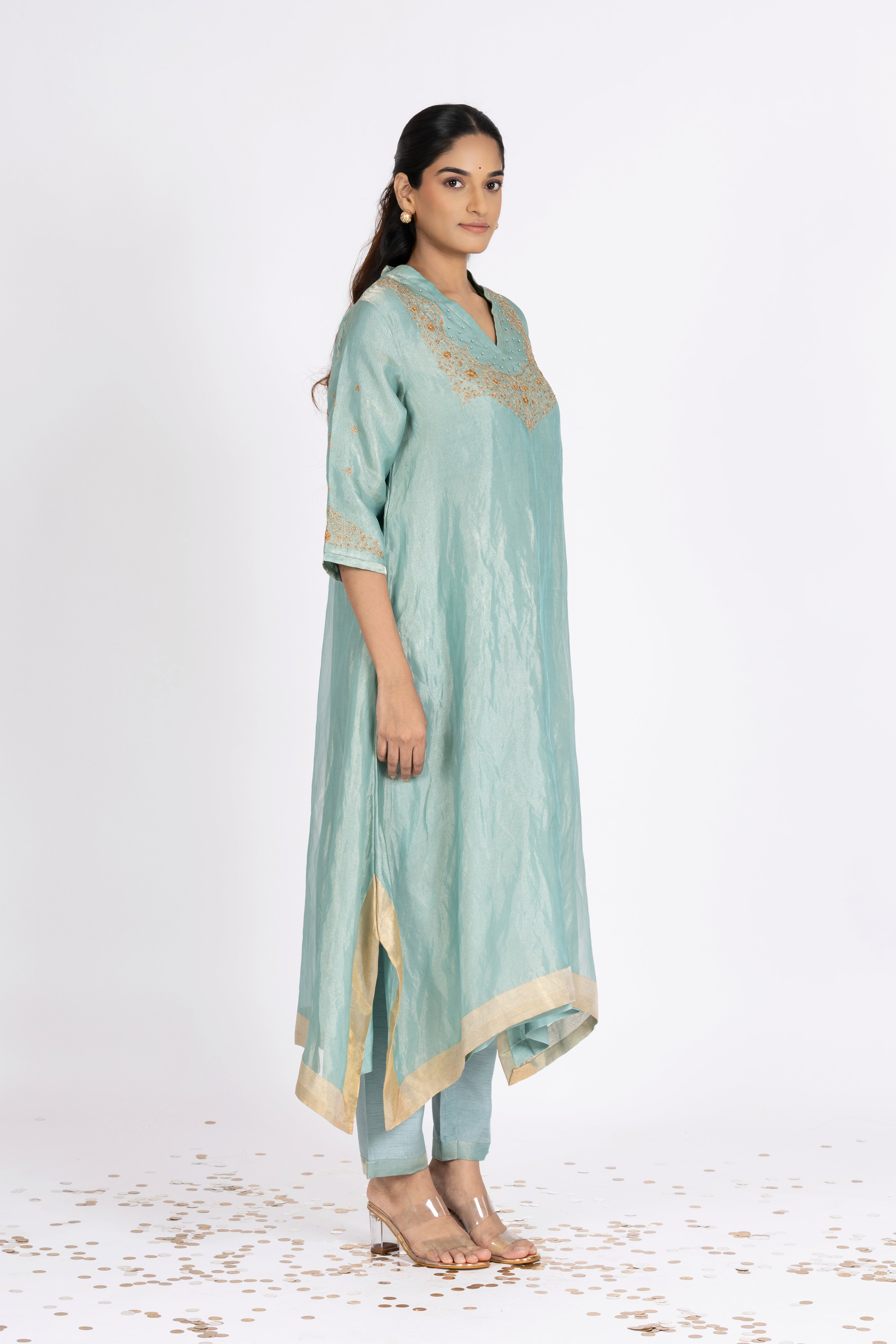 Woman wearing a blue Tissue kurta with gold embroidery on a white background
