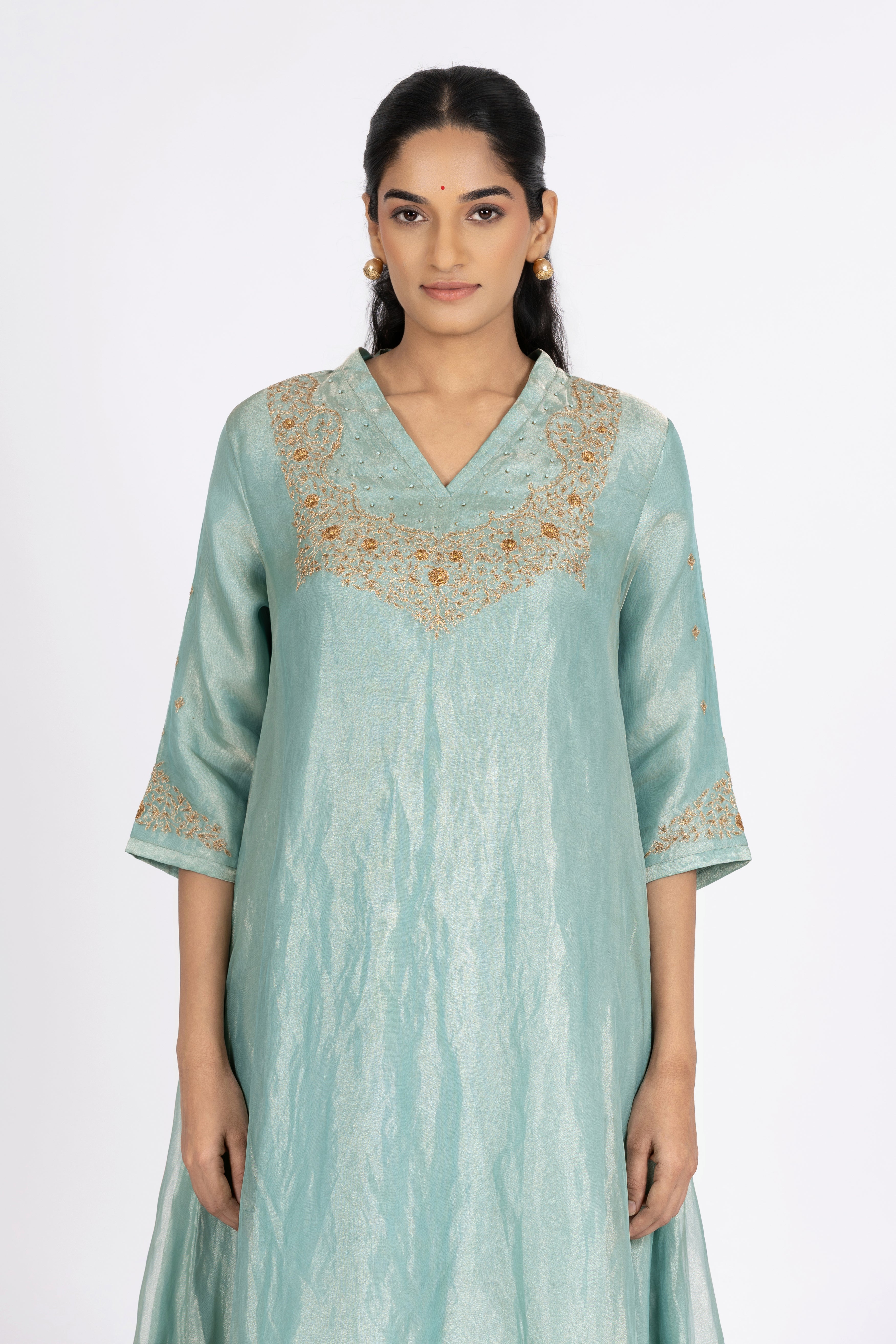 Woman wearing a blue Tissue kurta with gold embroidery on a white background