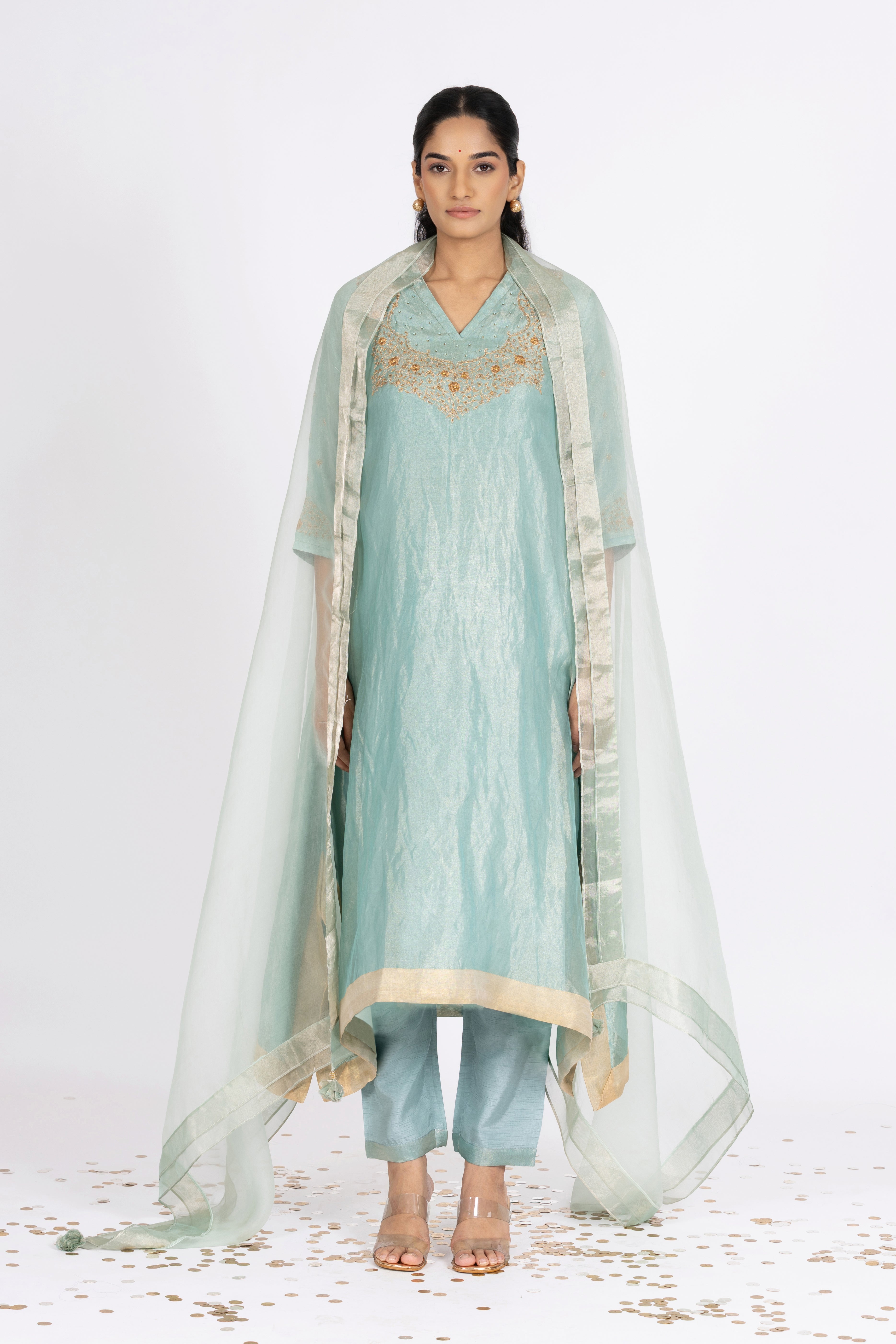 Woman wearing a blue Tissue fabric traditional Kurta with an Organza dupatta on a white background