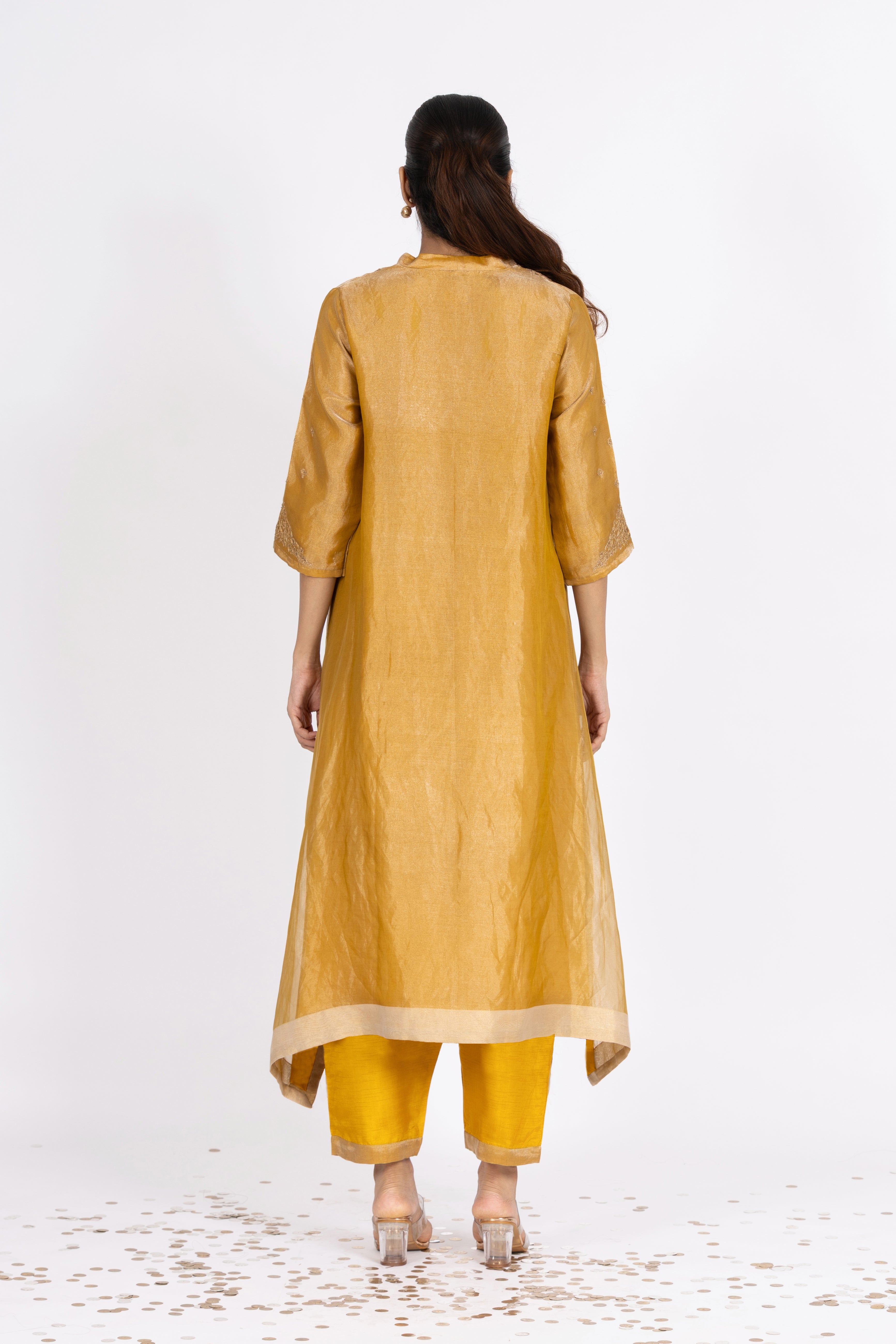 Woman wearing a Yellow Tissue kurta with gold embroidery on a white background