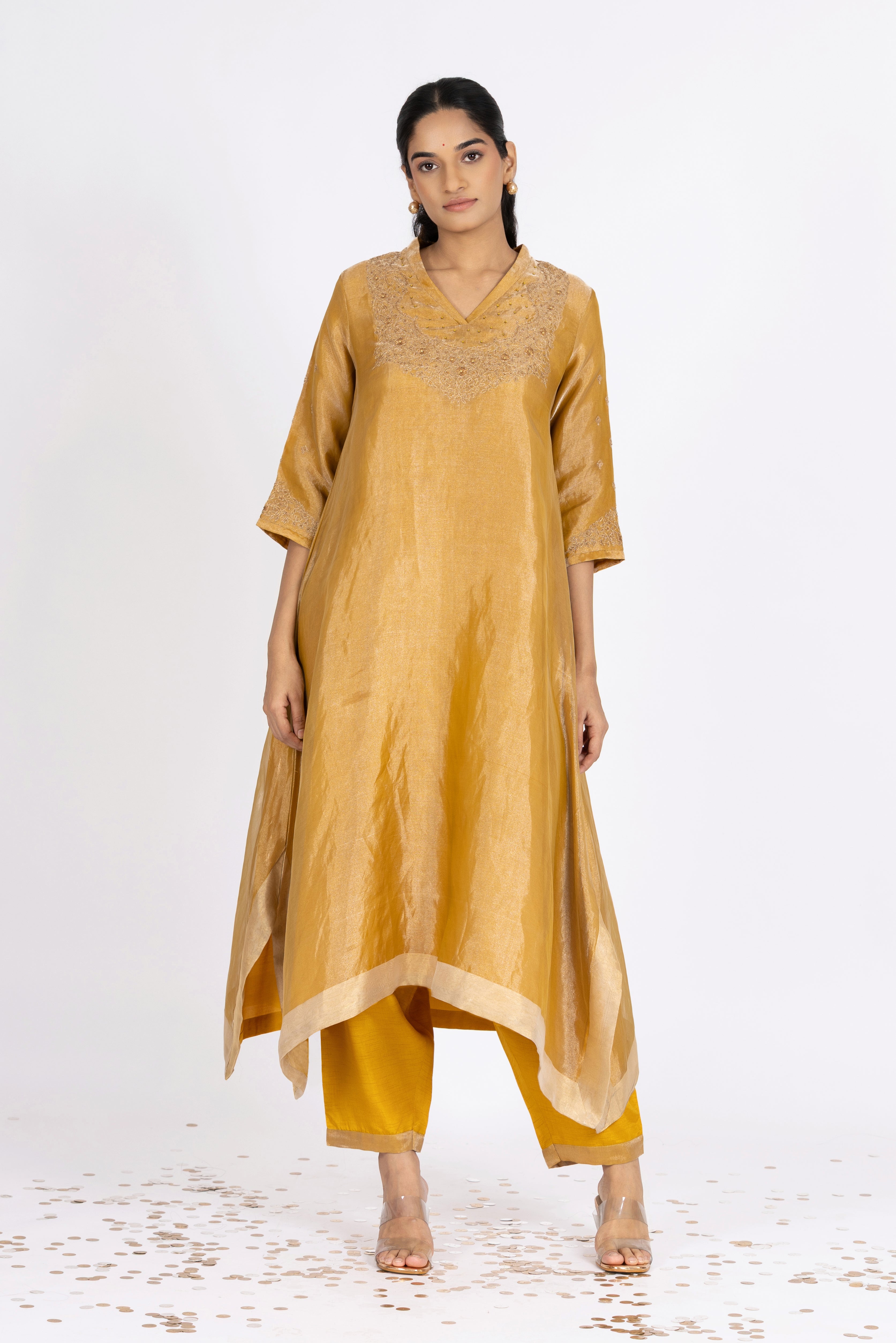 Woman wearing a Yellow Tissue kurta with gold embroidery on a white background