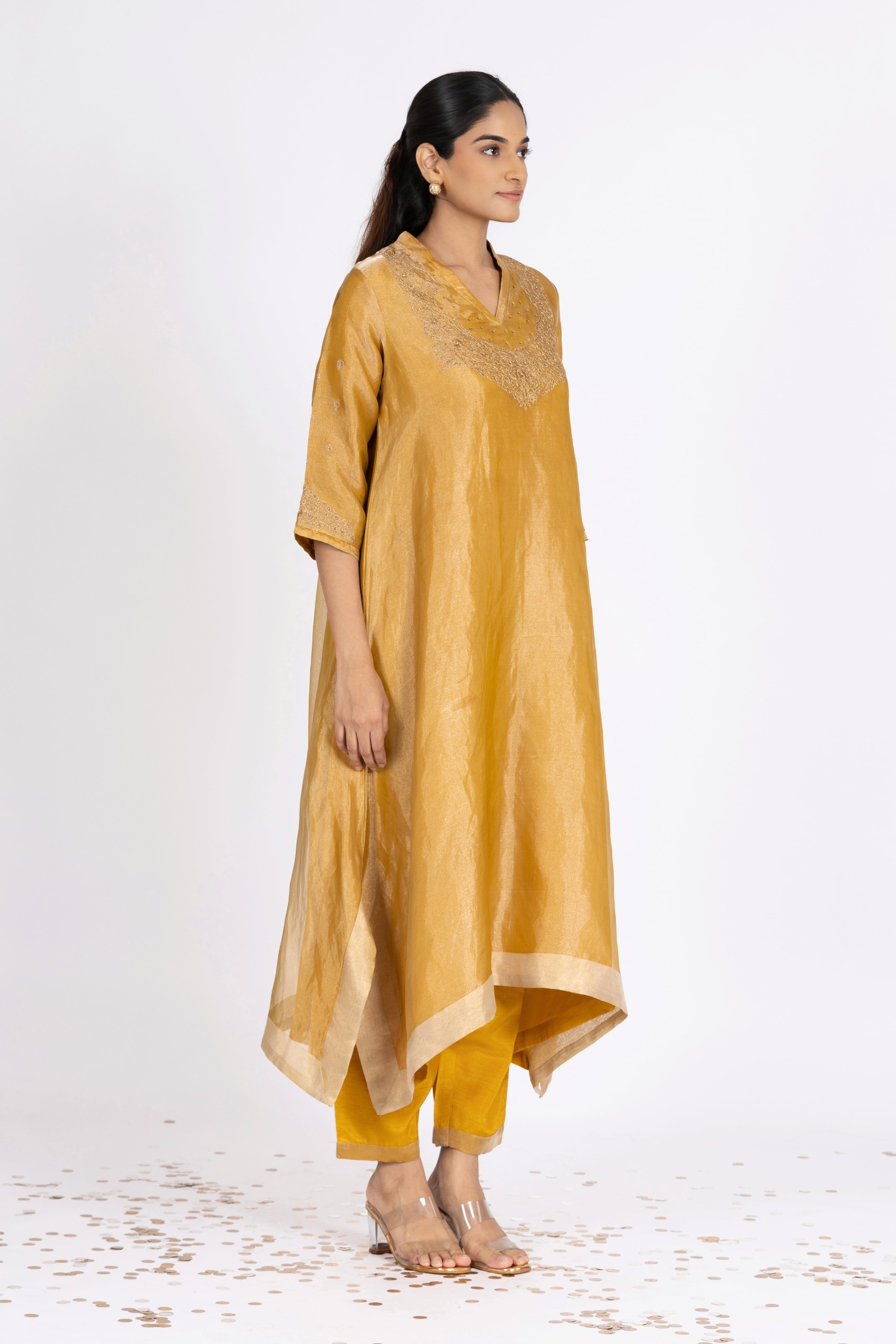 Woman wearing a Yellow Tissue kurta with gold embroidery on a white background