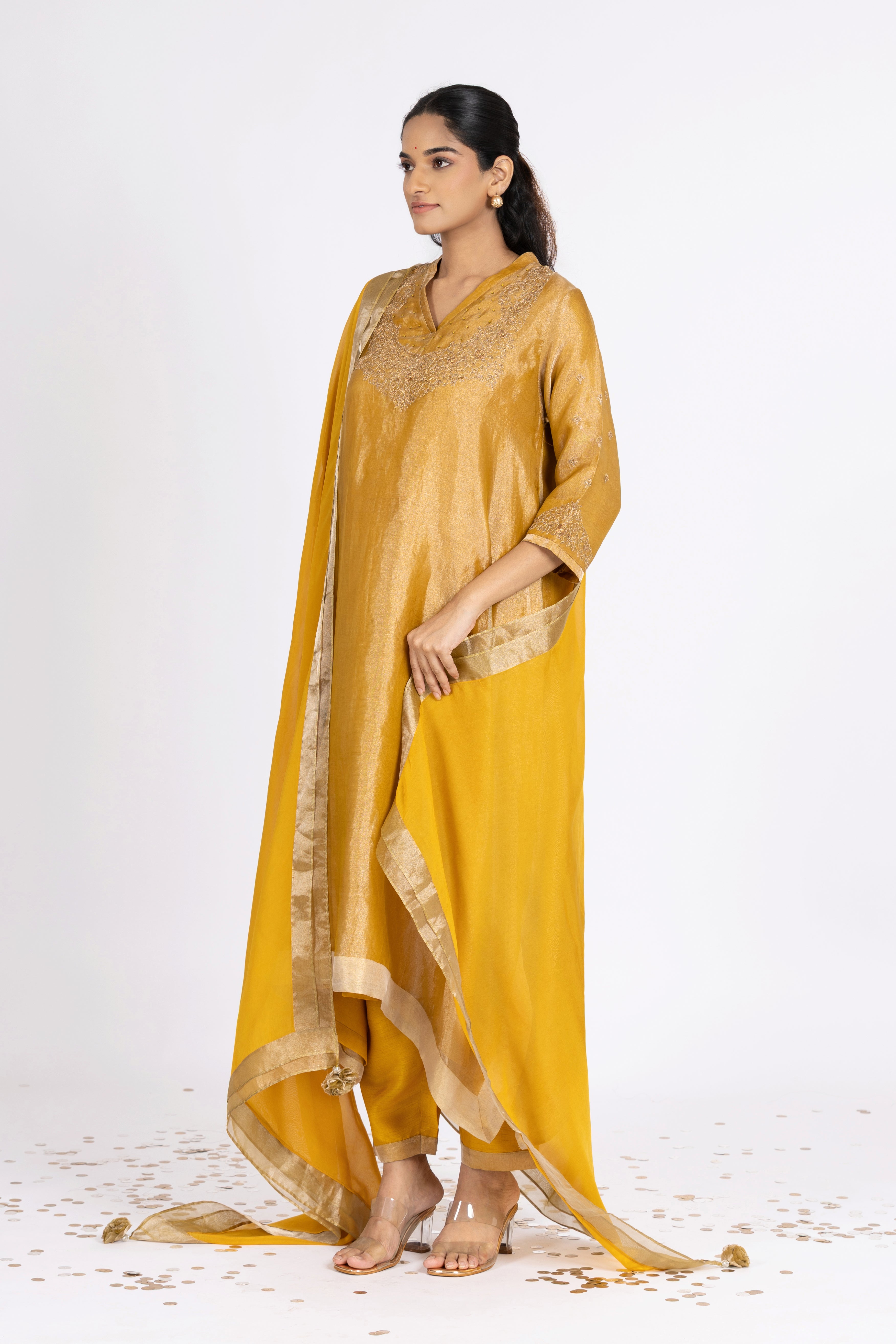Woman wearing a Yellow Tissue kurta with gold embroidery on a white background