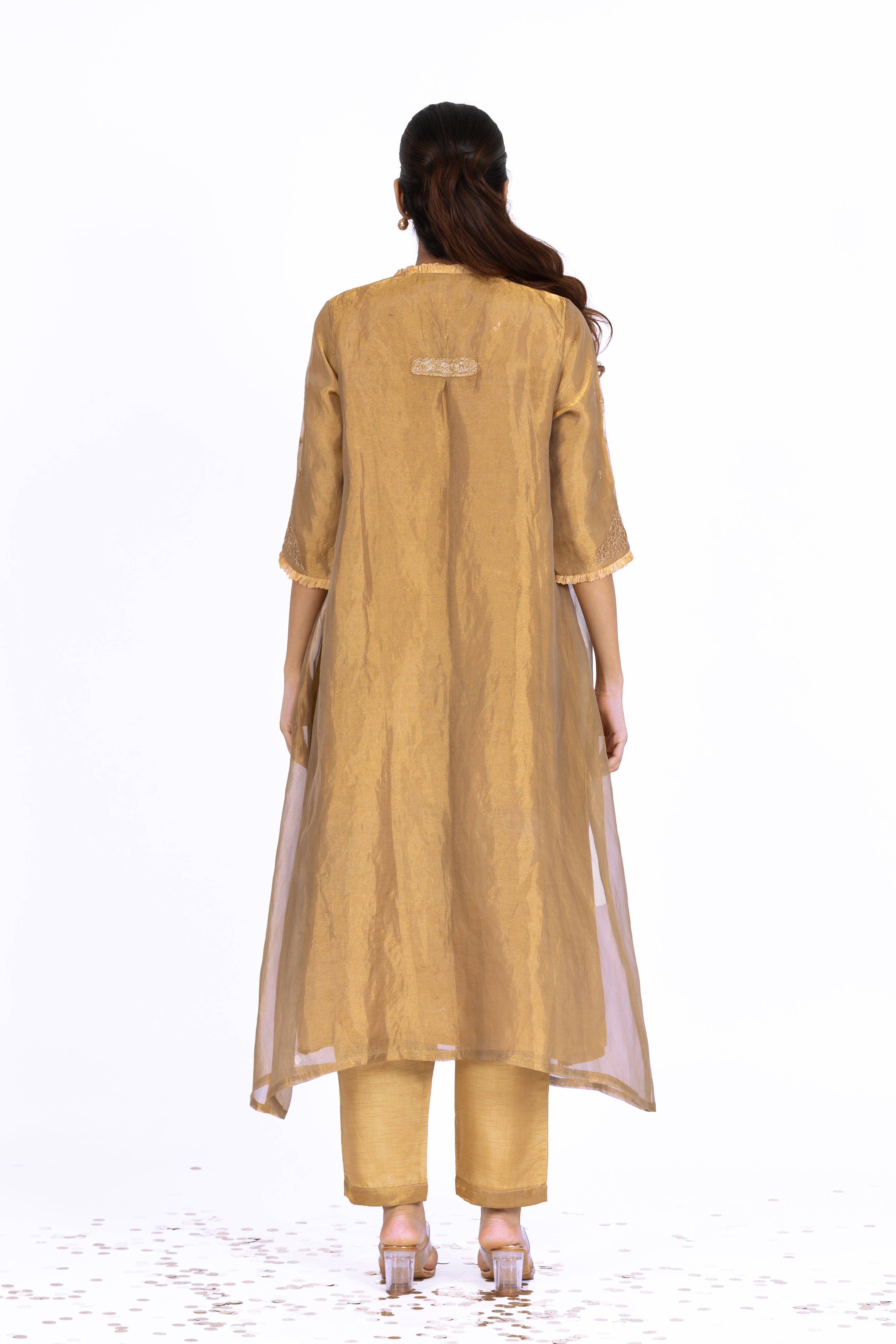 Woman wearing a Golden Tissue kurta with gold embroidery on a white background