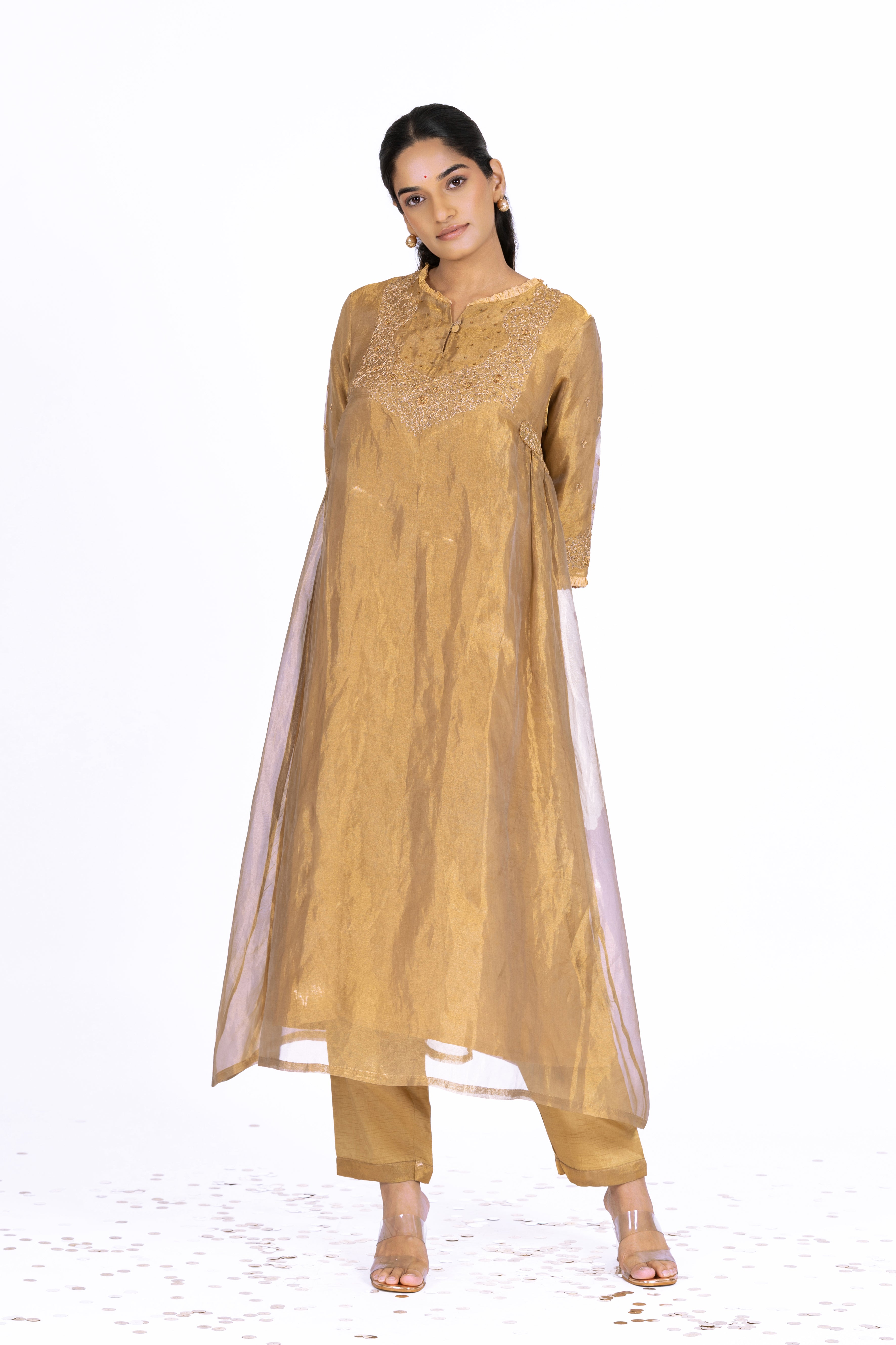 Woman wearing a Golden Tissue kurta with gold embroidery on a white background
