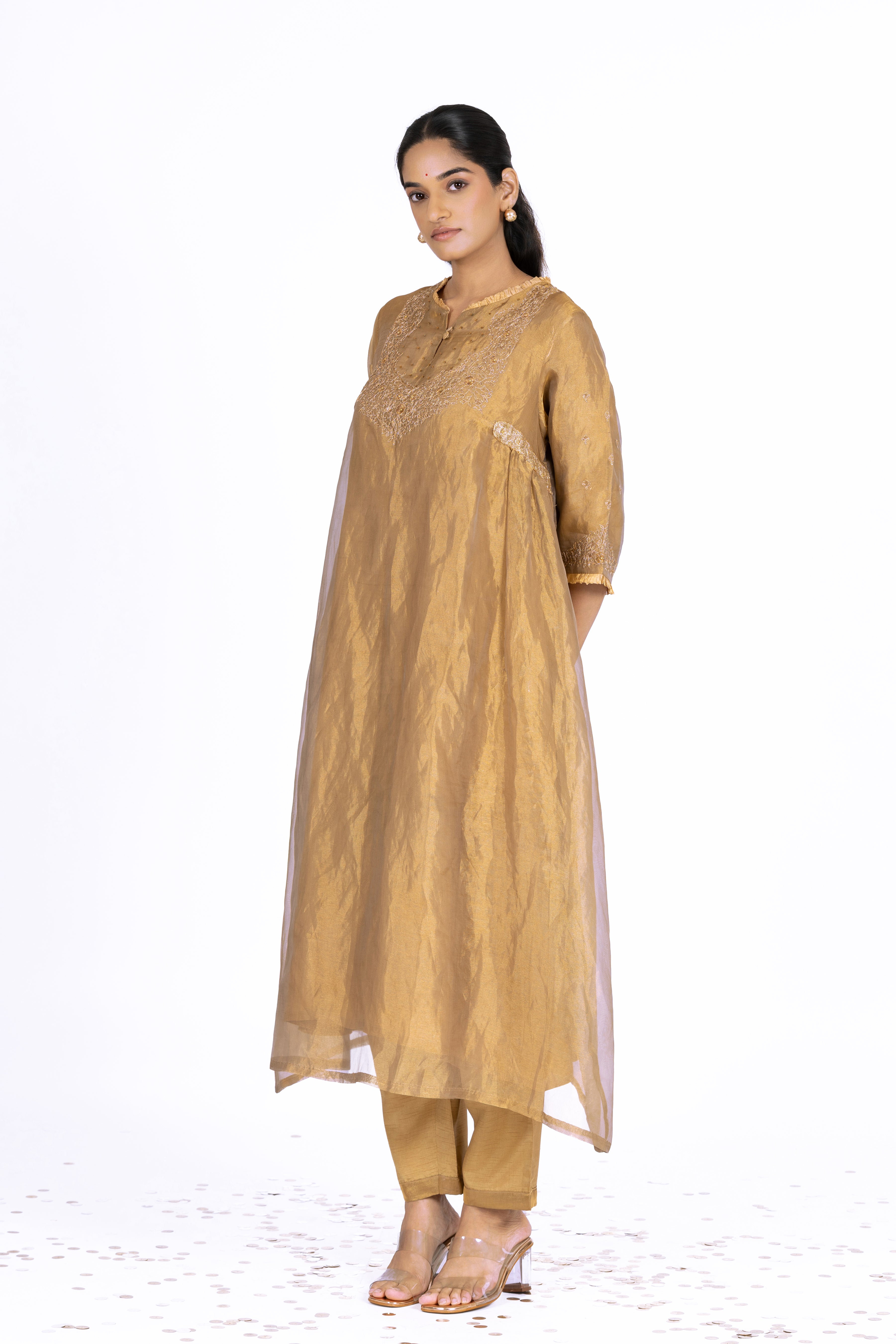 Woman wearing a Golden Tissue kurta with gold embroidery on a white background