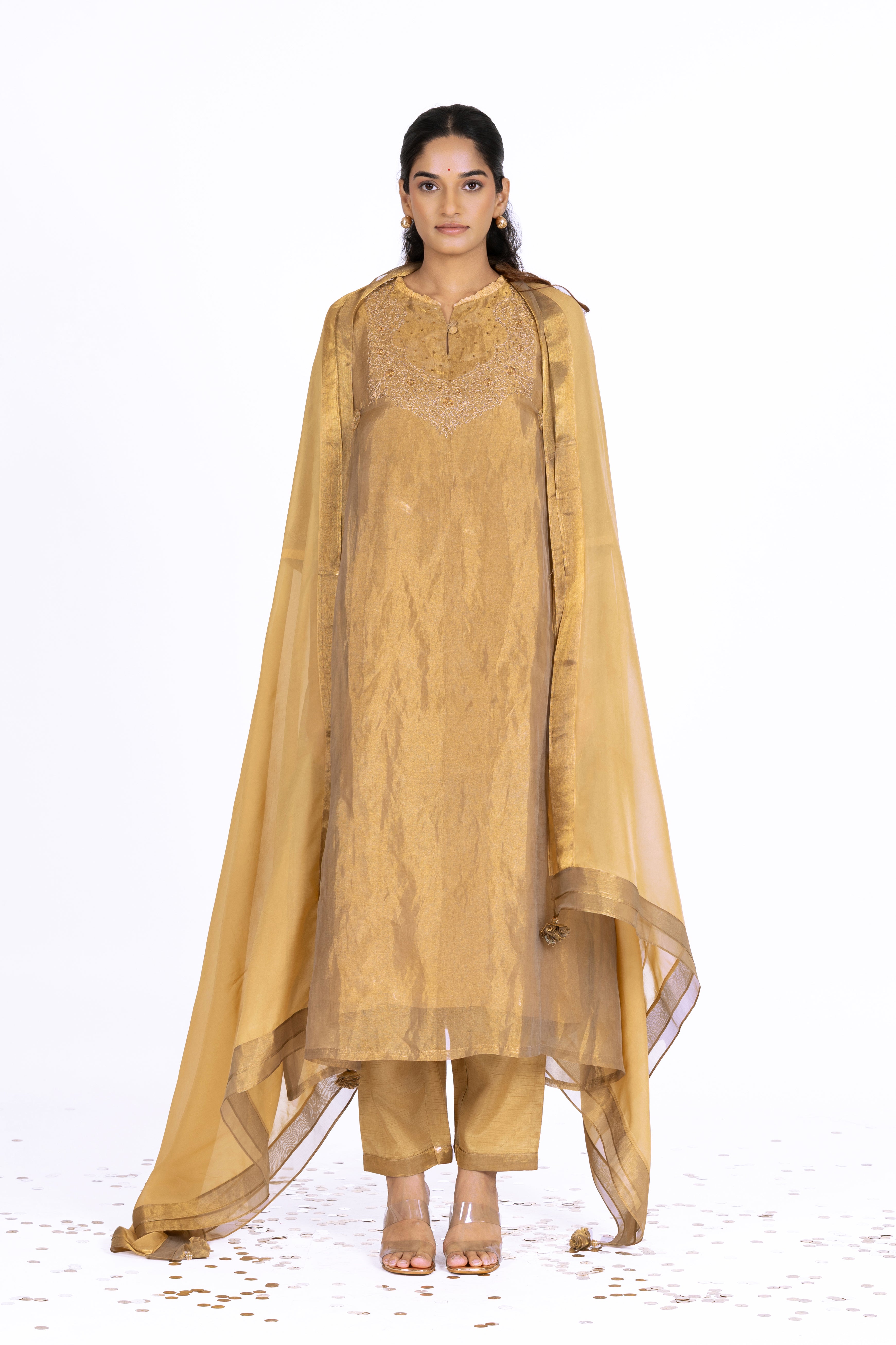 Woman wearing a Golden Tissue kurta with gold embroidery on a white background