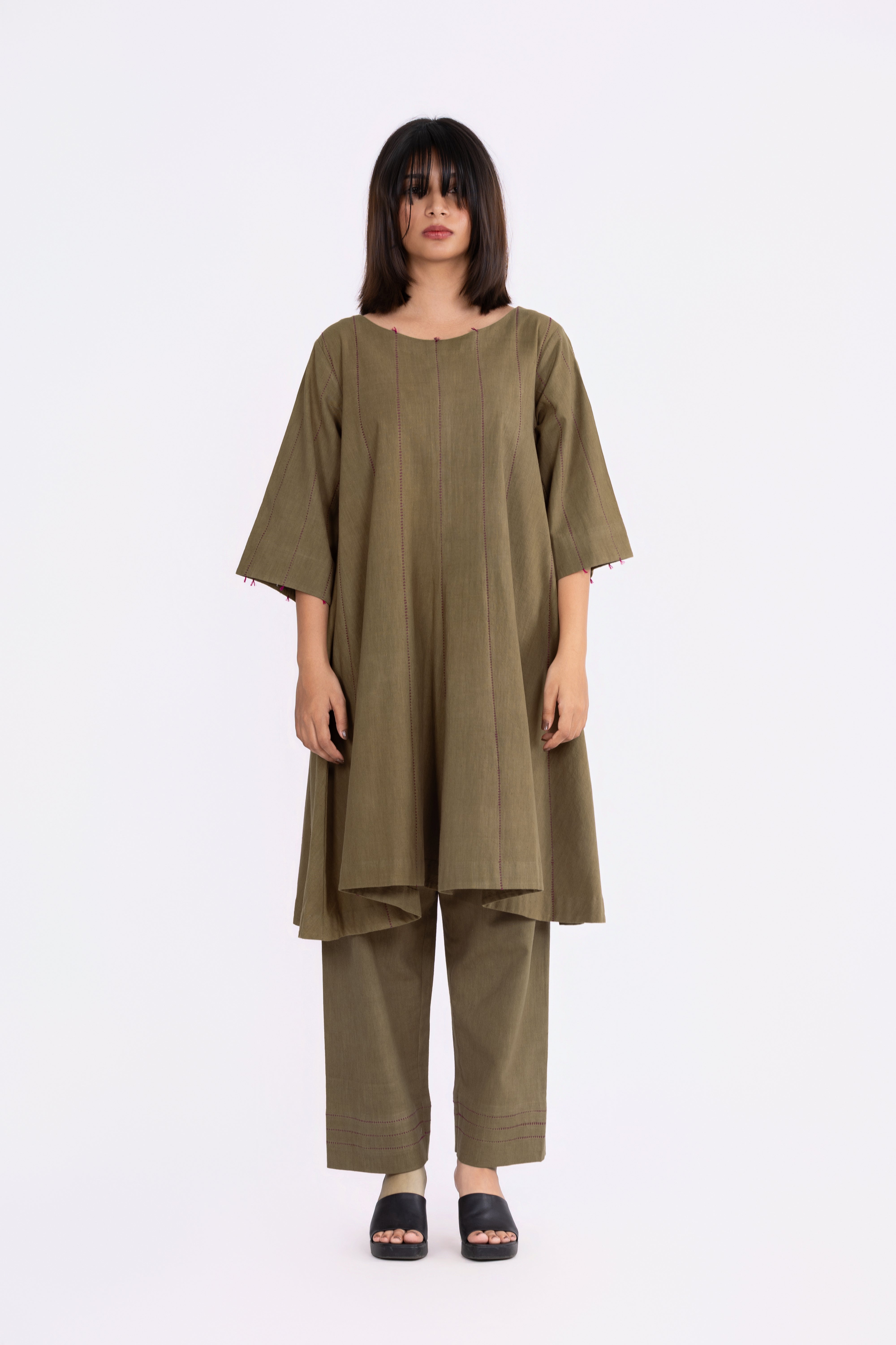 Woman wearing an olive green outfit on a white background