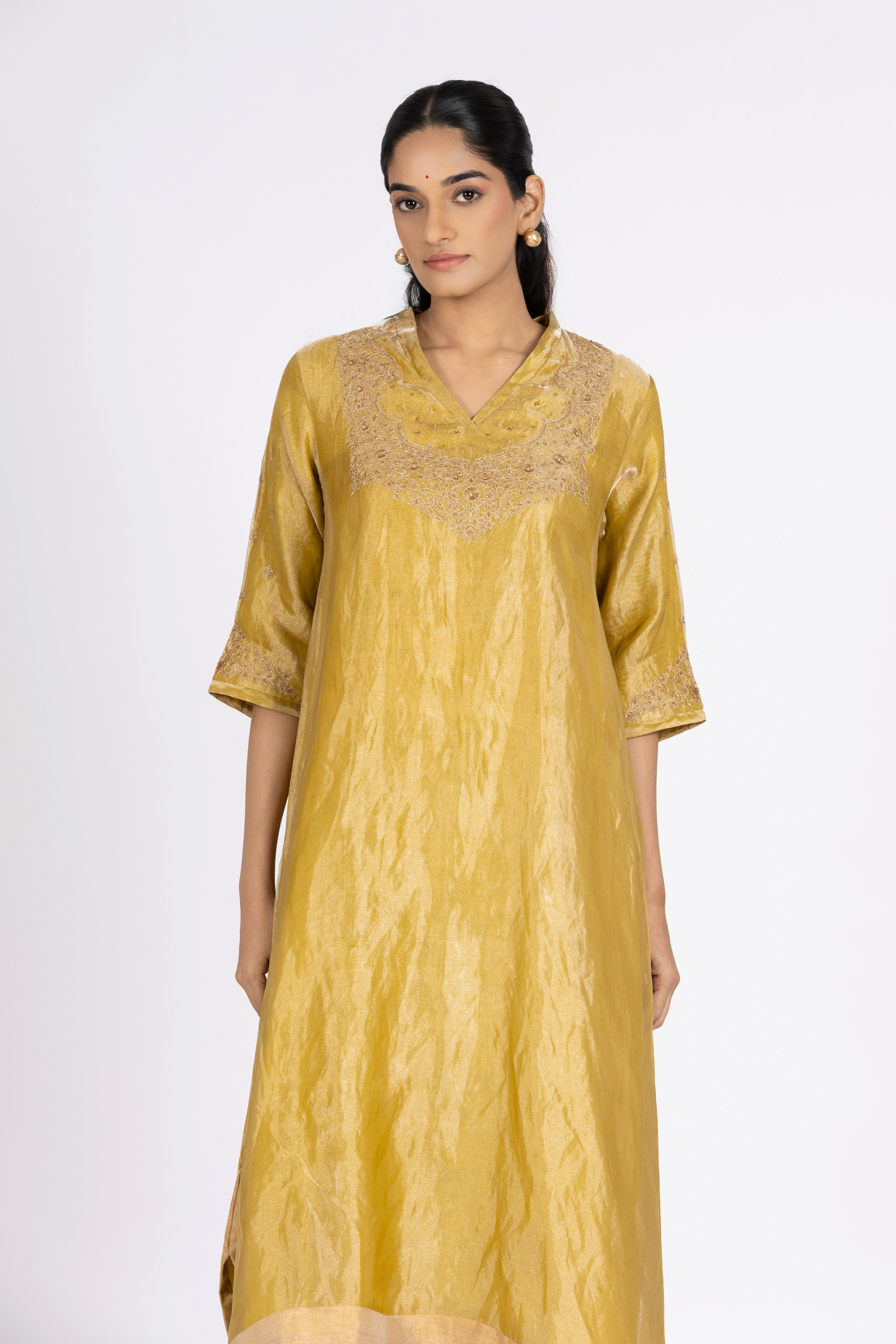 Woman wearing a Green Tissue kurta with gold embroidery on a white background