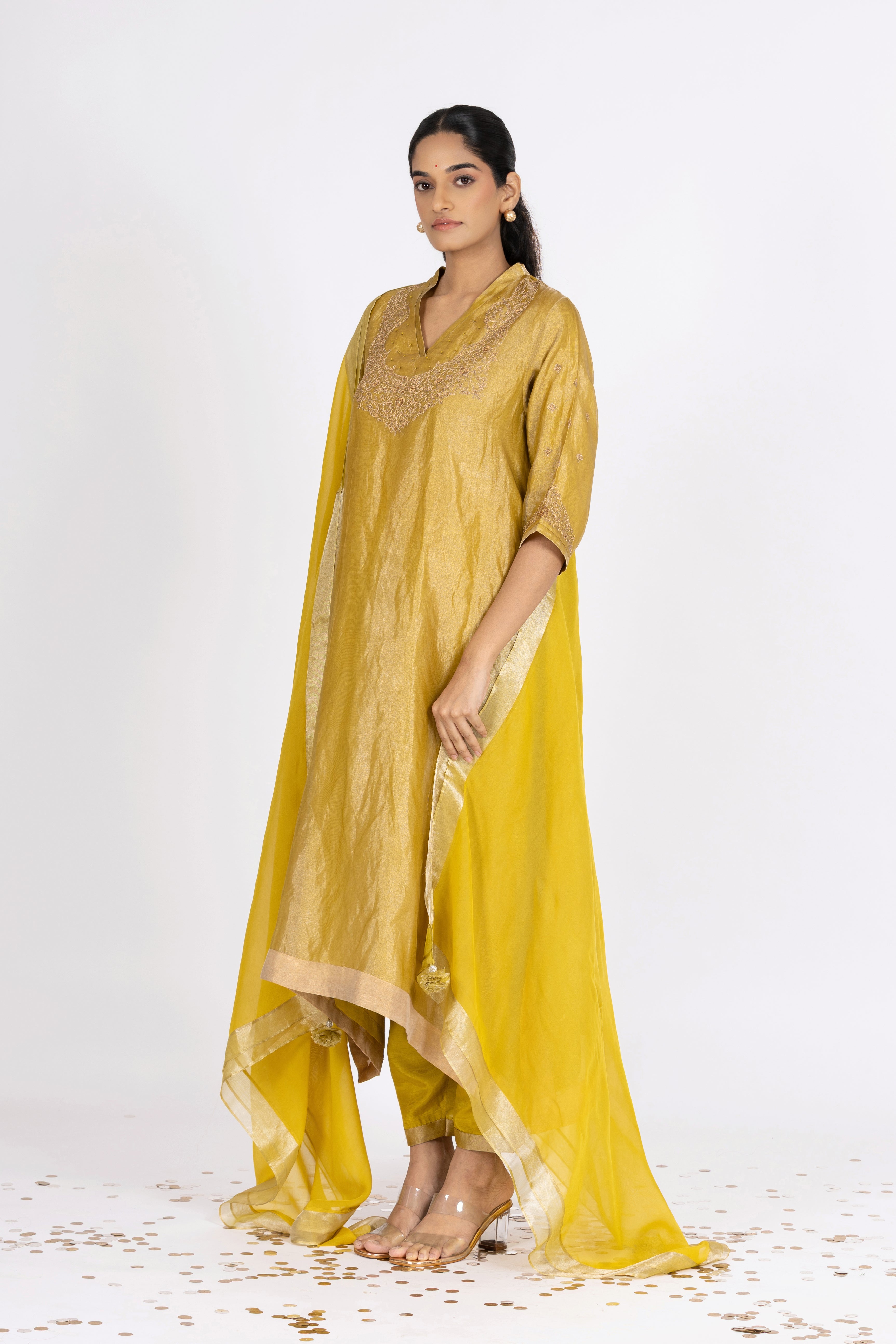 Woman wearing a Green Tissue kurta with gold embroidery on a white background