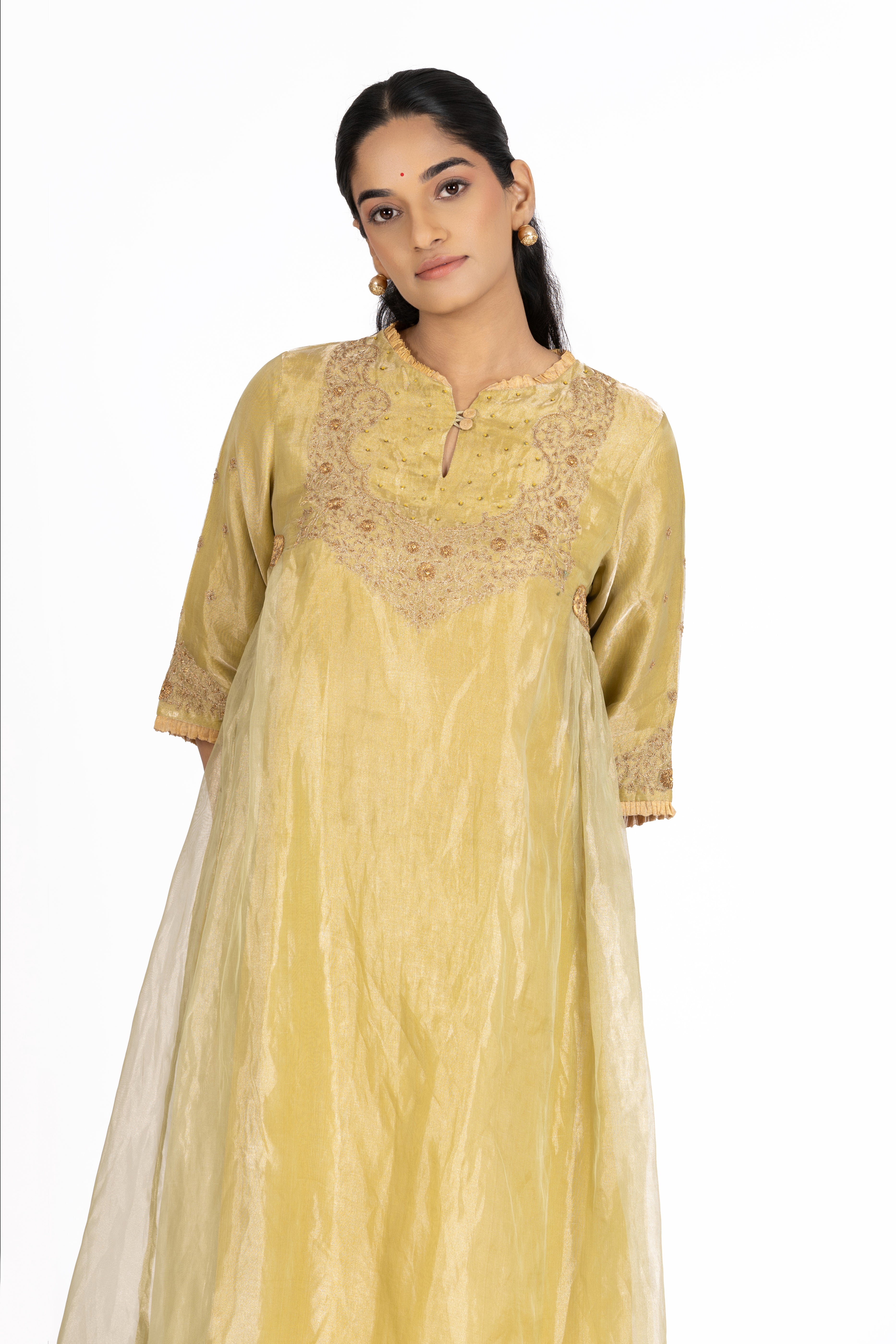 Woman wearing a Mustard Tissue kurta with gold embroidery on a white background