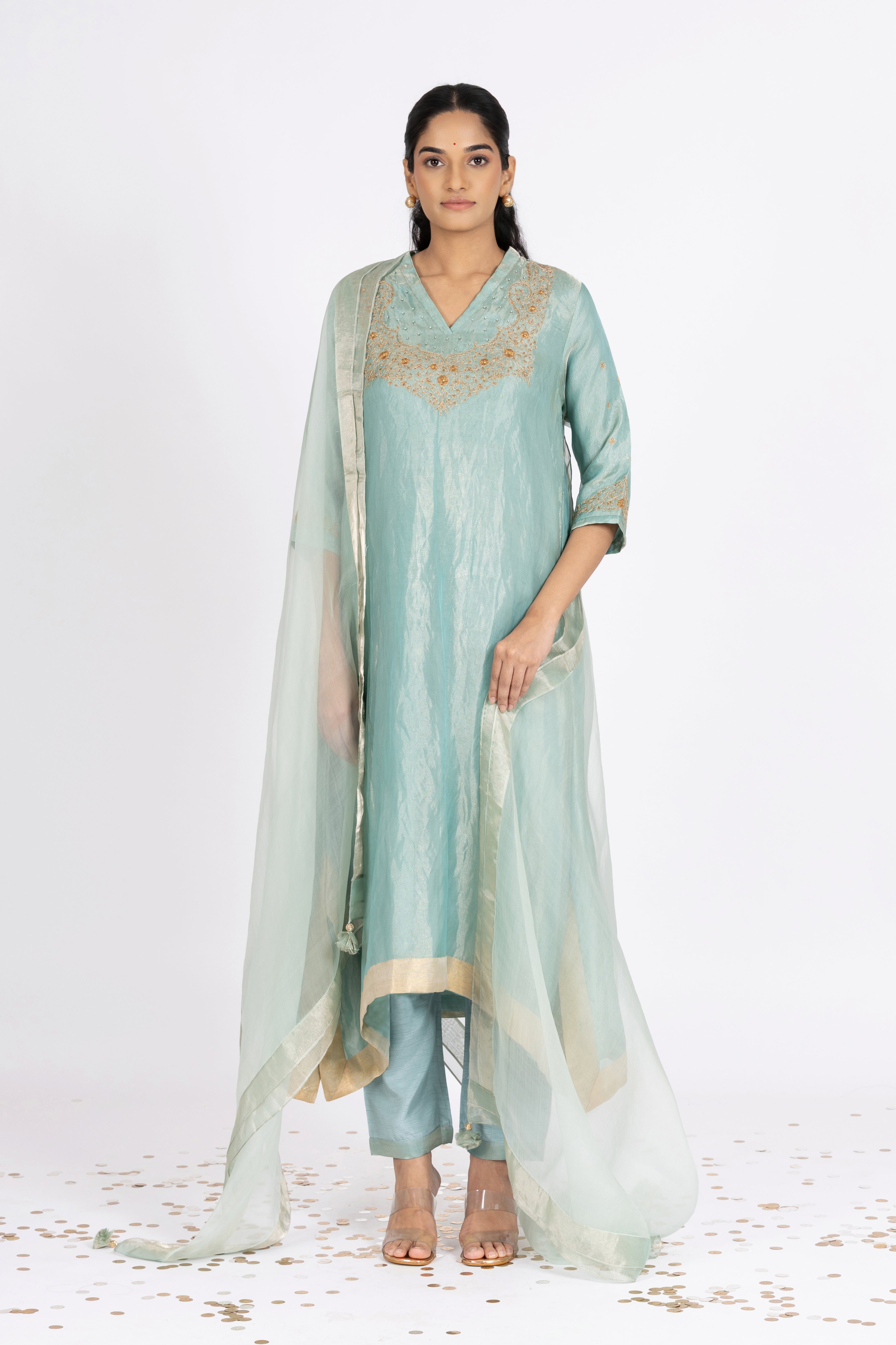 Woman wearing a blue Tissue kurta with gold embroidery on a white background
