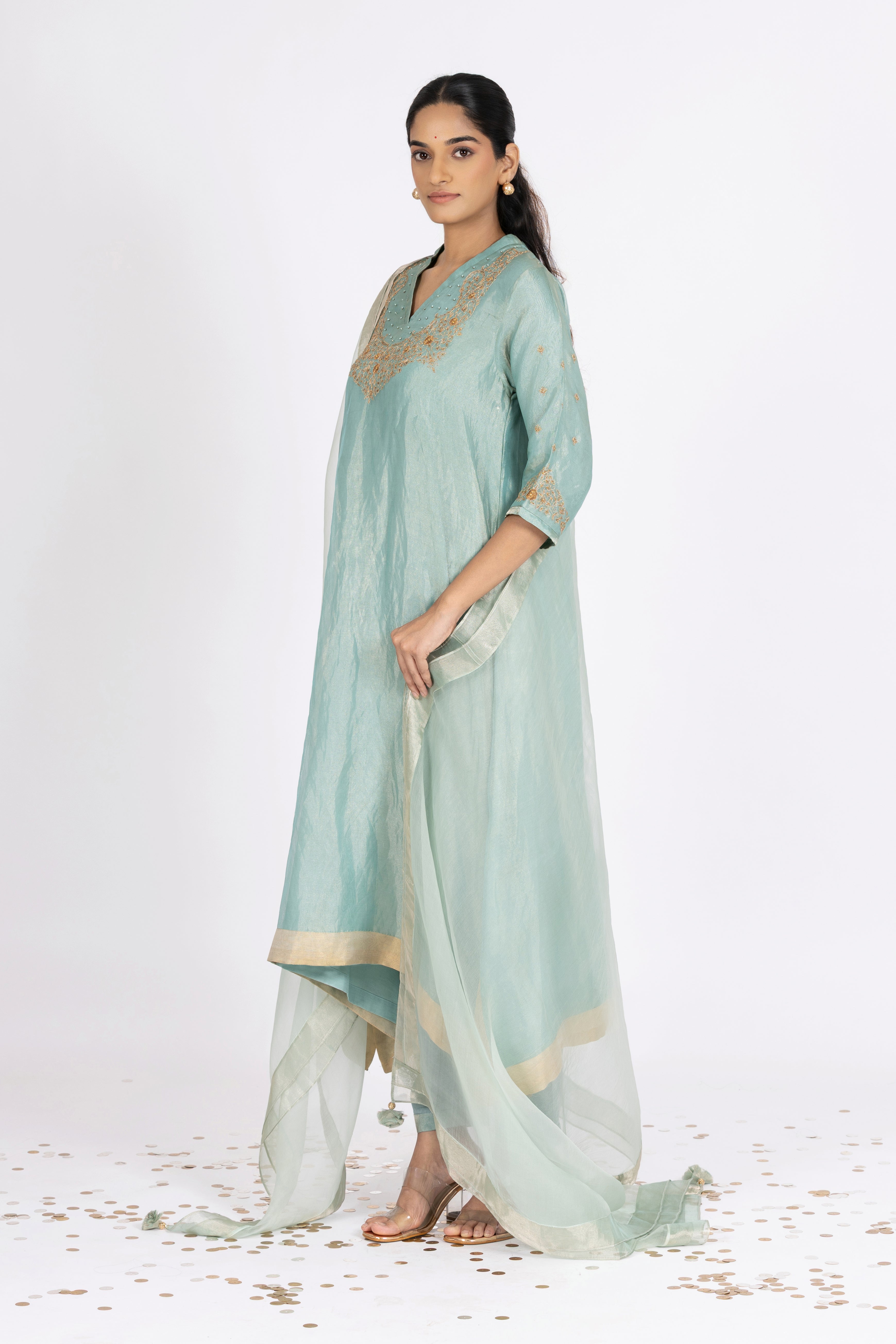 Woman wearing a blue Tissue kurta with gold embroidery on a white background