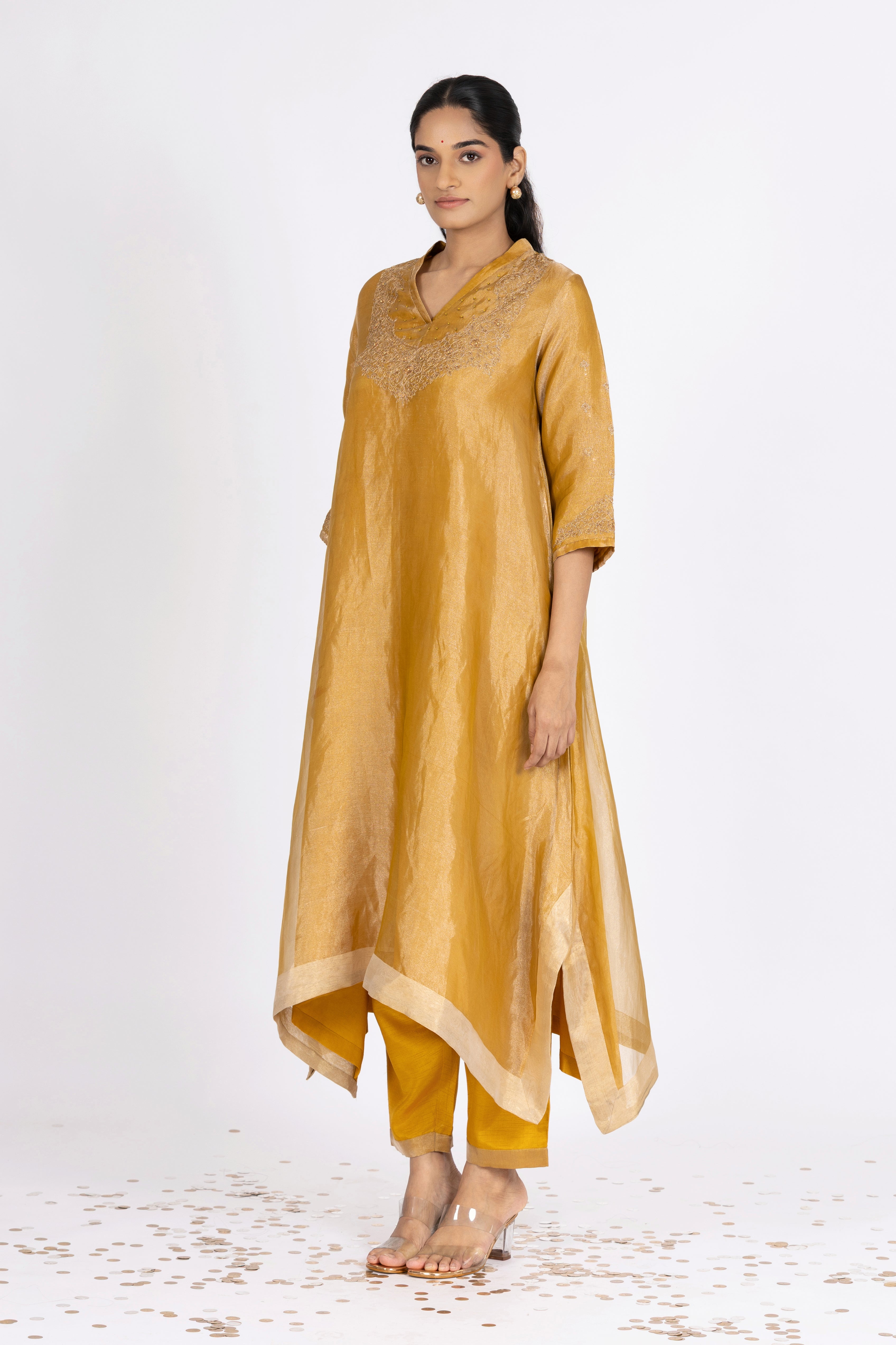 Woman wearing a Yellow Tissue kurta with gold embroidery on a white background
