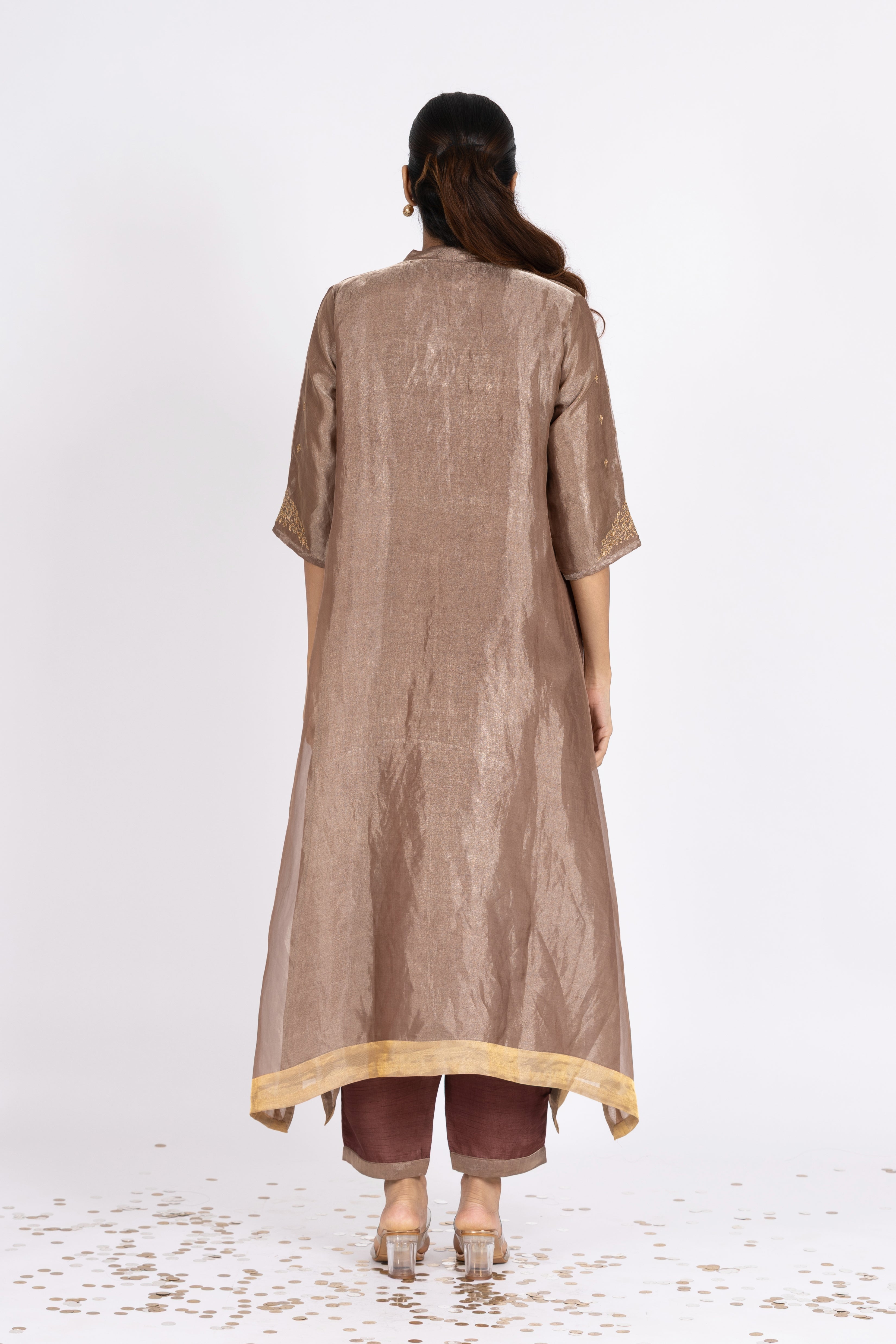 Woman wearing a Pink Tissue kurta with gold embroidery on a white background
