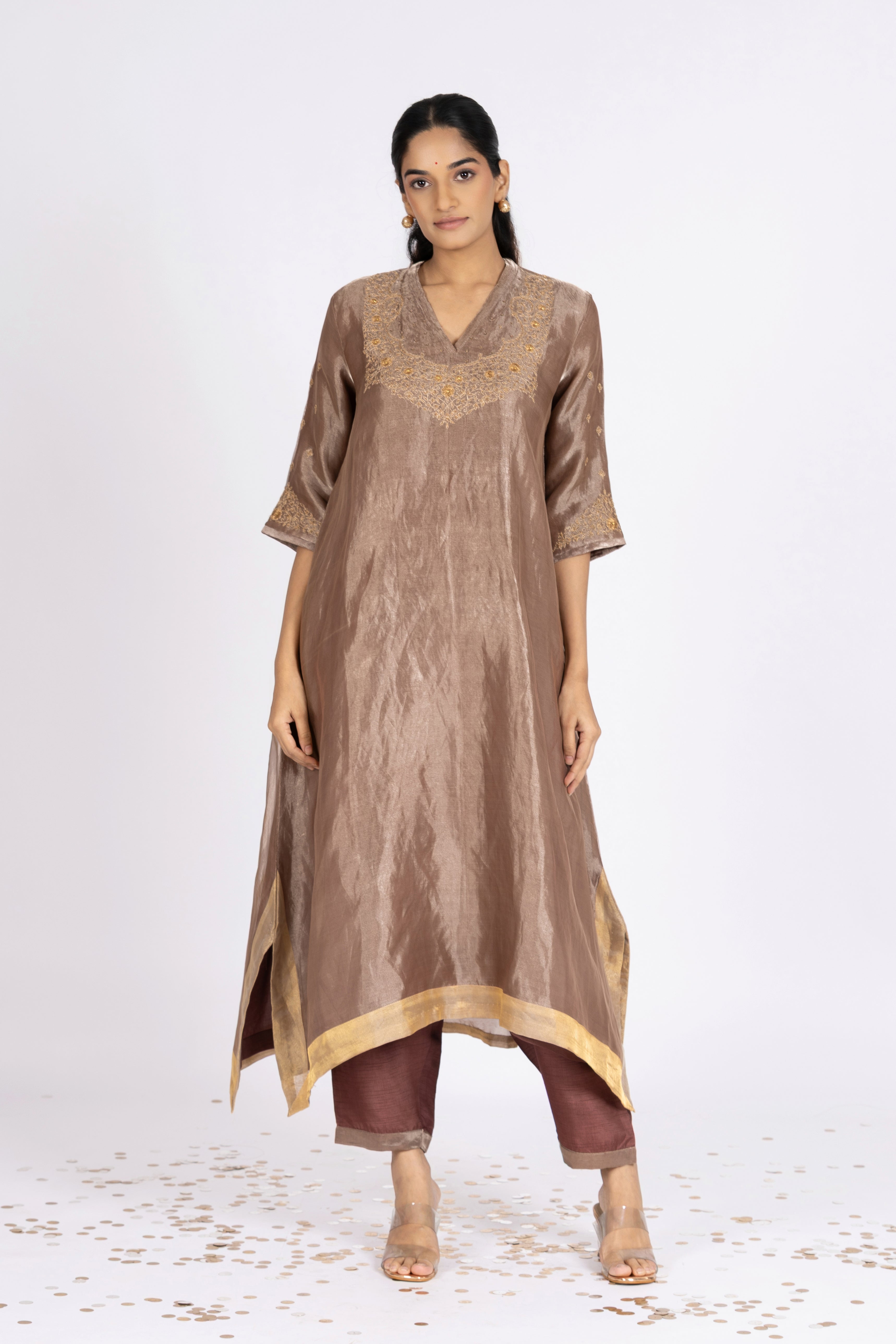 Woman wearing a Brown Tissue kurta with gold embroidery on a white background